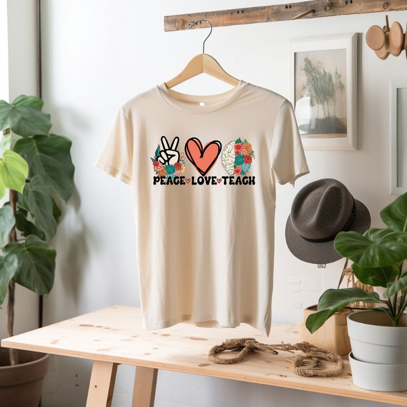 Peace Love Teach PNG Sublimation Design on a soft cream graphic tee