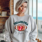 Show your support for the Philadelphia Eagles with this stylish sweatshirt, featuring a football and fun lips and tongue design. Complete with the team's iconic slogan "Fly Eagles Fly" and the distinctive Philadelphia wordmark, on a grey sweatshirt. 