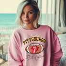 Geer up for game day with this Pittsburgh Steelers sweatshirt, featuring a football and playful lips and tongue design. Emblazoned with the team's iconic slogan "Steel Curtain" and the distinctive Pittsburgh wordmark, on a pink sweatshirt. 