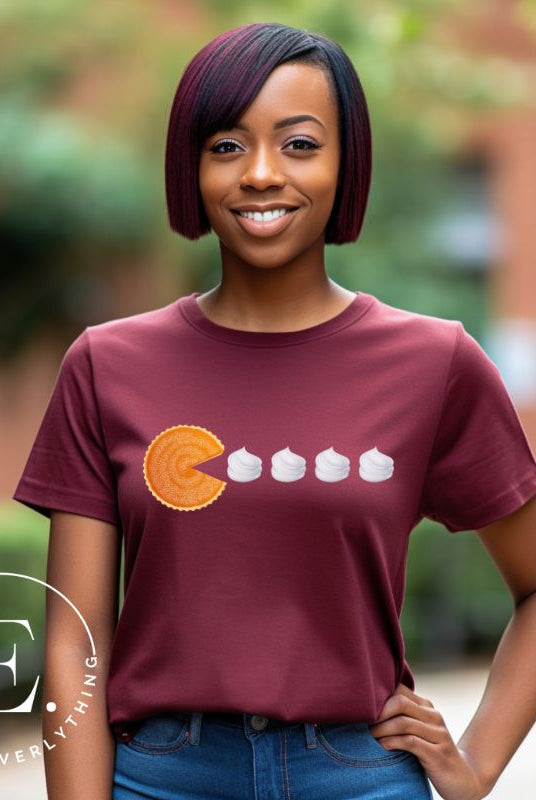 Level up your style with our playful t-shirt featuring a pumpkin pie shaped like Pac-Man devouring whipped cream swirls on a  maroon shirt. 
