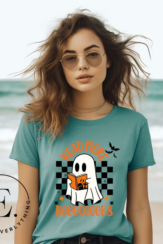 Get haunting stylish with our Halloween Ghost Reading t-shirt! Featuring a ghost engrossed in a book, it reads 'Read More Booooooks.' Perfect for bookworms and Halloween book enthusiasts on a a teal shirt. 