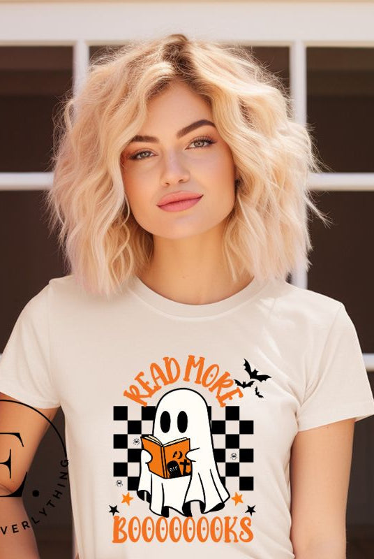 Get haunting stylish with our Halloween Ghost Reading t-shirt! Featuring a ghost engrossed in a book, it reads 'Read More Booooooks.' Perfect for bookworms and Halloween book enthusiasts on a soft cream shirt. 