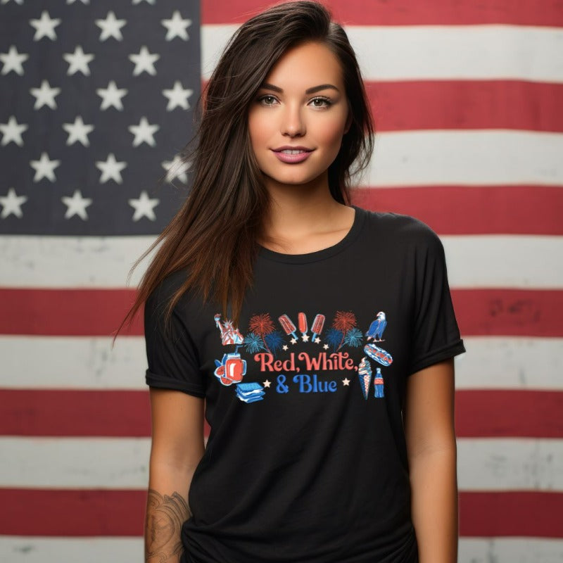 A vibrant graphic tee for the USA July 4th celebration featuring the text "Red White Blue" in bold and patriotic colors. The design is filled with various images associated with July 4th, including fireworks, American flags, stars, and stripes, evoking a sense of national pride and celebration on a black graphic tee.