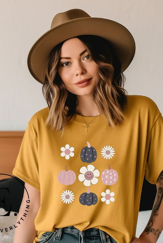 Step into retro autumn vibes with our trendy t-shirt. Featuring a delightful combination of pumpkins and retro flowers, on a mustard colored shirt. 