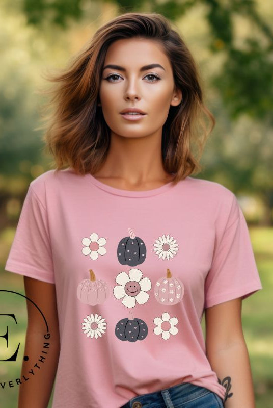 Step into retro autumn vibes with our trendy t-shirt. Featuring a delightful combination of pumpkins and retro flowers, on a pink shirt. 