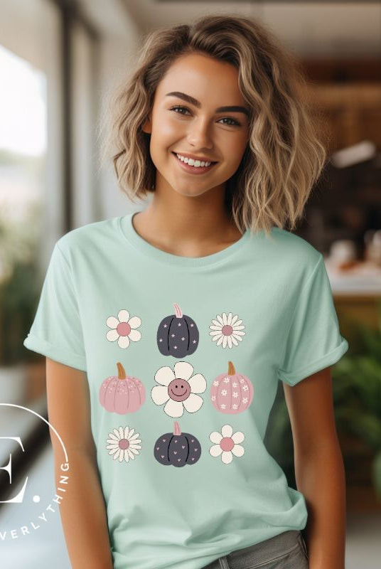 Step into retro autumn vibes with our trendy t-shirt. Featuring a delightful combination of pumpkins and retro flowers, on a mint shirt. 