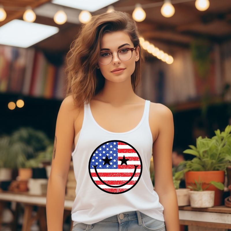 Close-up of a USA July 4th graphic Next Level Racerback Tank Top with a retro smiley face design on the front. The tank top features a patriotic color scheme and is perfect for adding a fun and playful touch to your Independence Day celebrations.