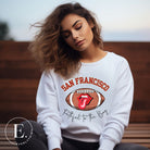 Show you allegiance to the San Francisco 49ers with this trendy sweatshirt, featuring a football and playful lips and tongue design. Emblazoned with the team's slogan "Faithful to the Bay" and the iconic San Francisco wordmark, on a white sweatshirt. 