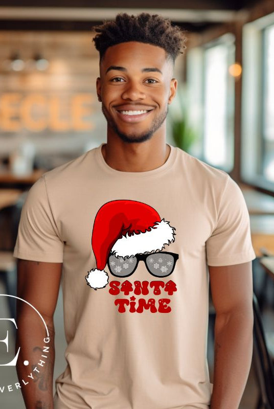Gear up for the holiday season with our men's Christmas Shirt featuring a Santa hat, Christmas sunglasses on a tan colored shirt. 