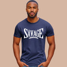 "Savage" in large, bold white letters with a football graphic underneath. The shirt is from Bella + Canvas and is made of 100% combed and ring-spun cotton on a navy shirt