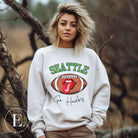 Support the Seattle Seahawks in style with this unique sweatshirt featuring a football and playful lips and tongue design. Featuring the team's slogan "Go Hawks" and the iconic Seattle wordmark, on a white sweatshirt. 