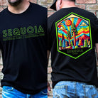 a colorful, detailed graphic of Sequoia National Park with the park's name and established year on the back, and a simplified text logo on the front on a black shirt.