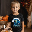 Dive into strength and style with our kids' shirt. Featuring a shark lifting weights with the empowering word 'strength' underneath on a black shirt. 