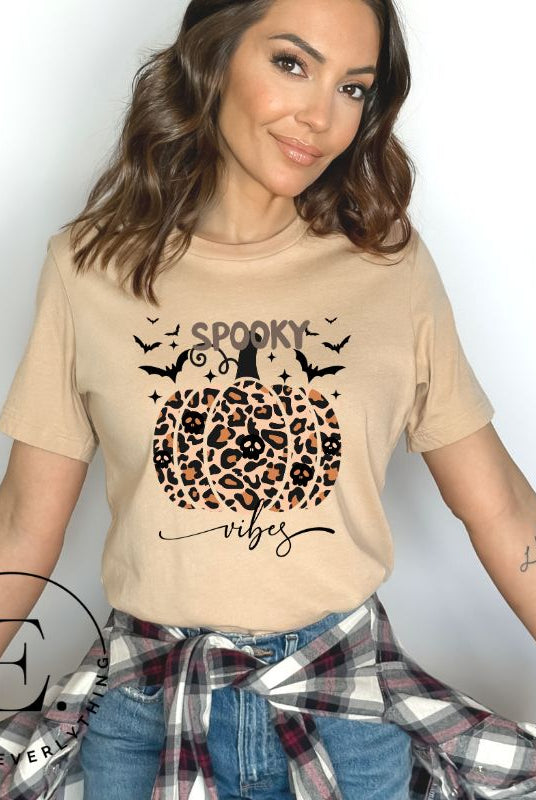 Get into Halloween spirit with our spooky vibes shirt featuring a unique cheetah print pumpkin adorned with skulls. As bats soar across the starry sky, embrace the eerie charm of this one-of-a-kind design on a tan shirt. 