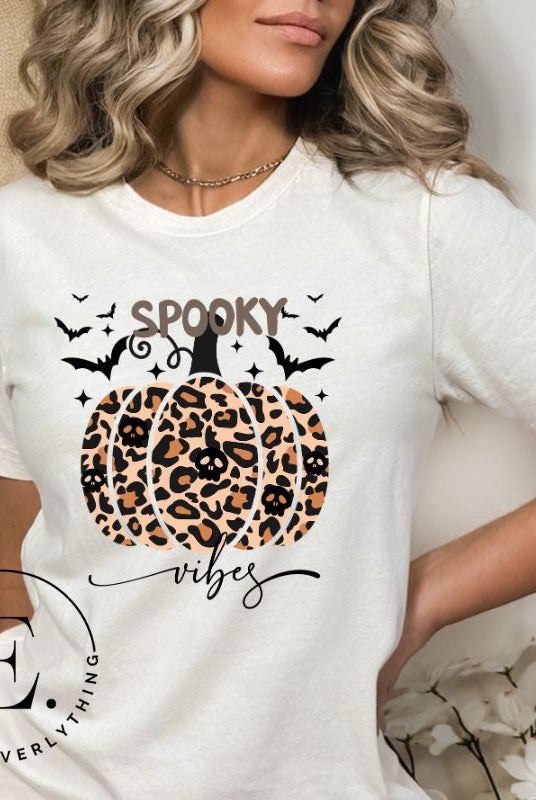 Get into Halloween spirit with our spooky vibes shirt featuring a unique cheetah print pumpkin adorned with skulls. As bats soar across the starry sky, embrace the eerie charm of this one-of-a-kind design on a white shirt. 