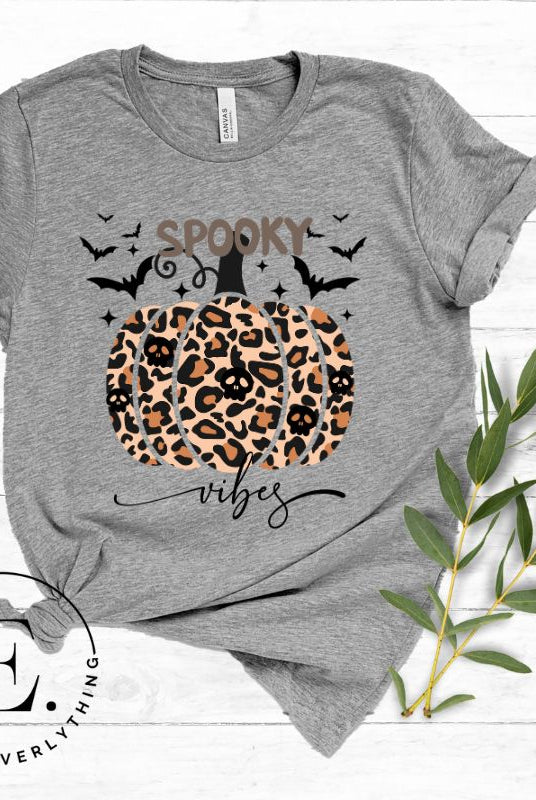 Get into Halloween spirit with our spooky vibes shirt featuring a unique cheetah print pumpkin adorned with skulls. As bats soar across the starry sky, embrace the eerie charm of this one-of-a-kind design on an a athletic heather grey shirt. 