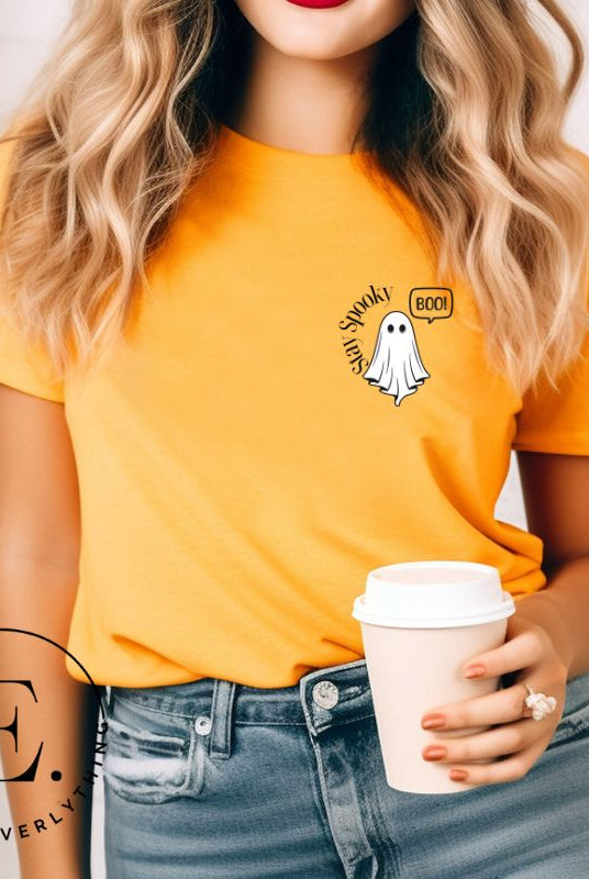 Get into the Halloween spirit with our spooktacular t-shirt. Featuring a friendly ghost holding a sign that says 'Boo' and the playful phrase "Stay Spooky"  on a yellow shirt. 