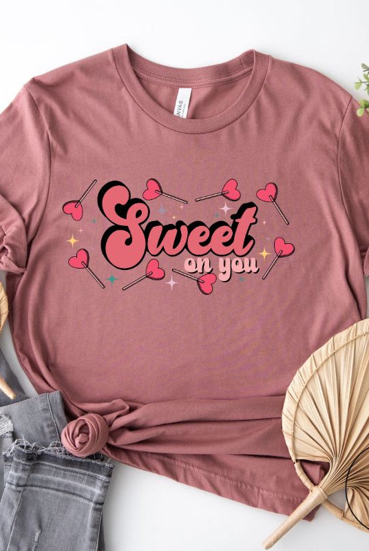 Spread sweetness this Valentine's Day with our PNG sublimation digital download! Create an adorable shirt adorned with heart lollipops and the charming saying "Sweet On You." Example of Sweet On You PNG sublimation digital download on a mauve shirt. 