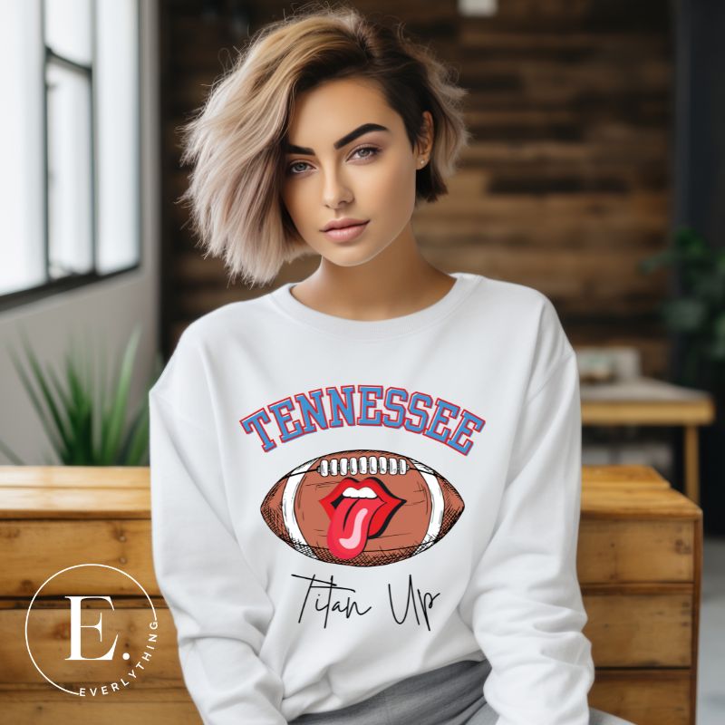 Elevate your game-day look with this Tennessee Titans sweatshirt, featuring a football and unique lips and tongue design. Complete with the team's rallying cry "Titan Up" and the iconic Tennessee wordmark, on a white sweatshirt. 