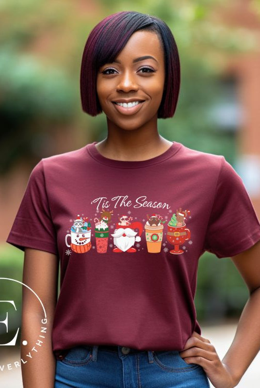 Wrap yourself in cozy holiday vibes with our Christmas coffee cup shirt. With a festive design that says "Tis The Season," this shirt captures the essence of warmth and joy. Perfect for coffee lovers who cherish the magic of the holidays on a maroon shirt. 