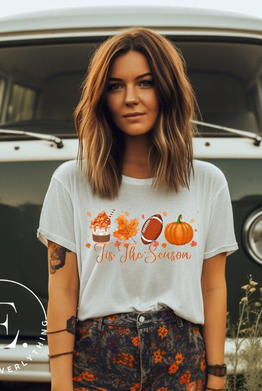 Get ready to welcome the fall season with our exclusive 'Tis The Season' football shirt! This vibrant design features fall coffee, leaves, football, and pumpkins, perfectly capturing the essence of autumn on a white shirt. 