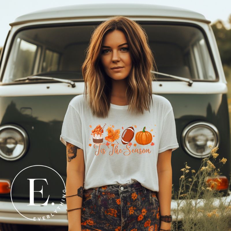 Get ready to welcome the fall season with our exclusive 'Tis The Season' football shirt! This vibrant design features fall coffee, leaves, football, and pumpkins, perfectly capturing the essence of autumn on a white shirt. 