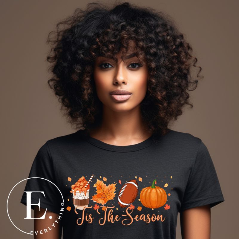 Get ready to welcome the fall season with our exclusive 'Tis The Season' football shirt! This vibrant design features fall coffee, leaves, football, and pumpkins, perfectly capturing the essence of autumn on a black shirt. 