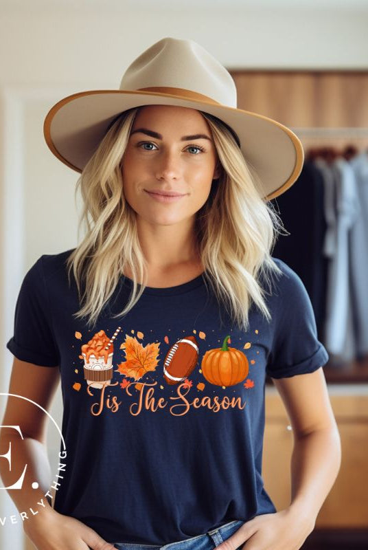 Get ready to welcome the fall season with our exclusive 'Tis The Season' football shirt! This vibrant design features fall coffee, leaves, football, and pumpkins, perfectly capturing the essence of autumn on a navy shirt. 