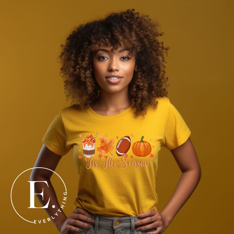 Get ready to welcome the fall season with our exclusive 'Tis The Season' football shirt! This vibrant design features fall coffee, leaves, football, and pumpkins, perfectly capturing the essence of autumn on a yellow shirt. 