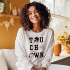 "TOUCHDOWN" letters, featuring a football helmet, field, and football graphics on a white sweatshirt. 