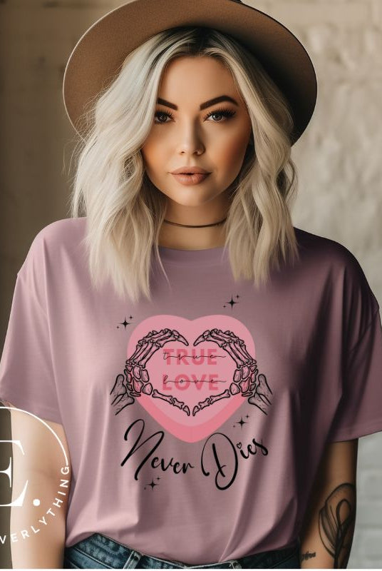 Embrace the unconventional with our Valentine's Day shirt featuring the bold statement "True Love, Never Dies" adorned with a heart and skeleton hands forming a heart shape on a mauve shirt. 