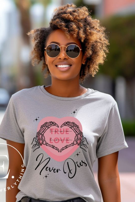 Embrace the unconventional with our Valentine's Day shirt featuring the bold statement "True Love, Never Dies" adorned with a heart and skeleton hands forming a heart shape on a grey shirt. 