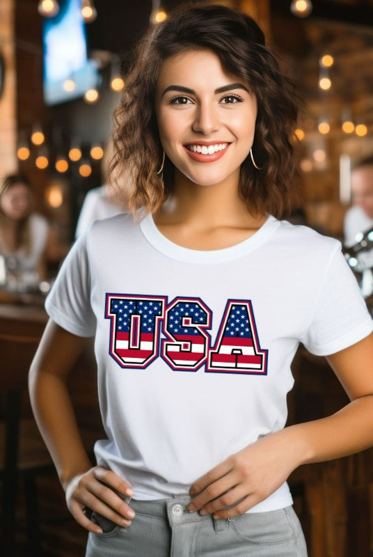 Eye-catching USA July 4th graphic tee showcasing 'USA' in vibrant American flag patterns on the front, adding a patriotic and bold statement to your wardrobe.