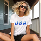 The alt text for the product photo could be: "Graphic tee with smokey blue lettering of 'USA' on the front, on a white background - ideal for showcasing your patriotic spirit on July 4th.