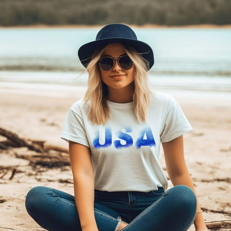 The alt text for the product photo could be: "Graphic tee with smokey blue lettering of 'USA' on the front, on a white background - ideal for showcasing your patriotic spirit on July 4th.