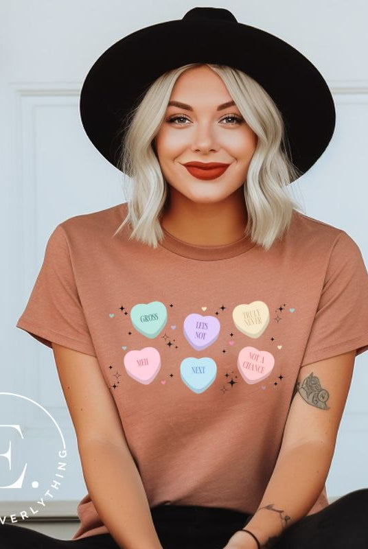 Embrace a humorous take on Valentine's Day with our shirt featuring candy hearts with unconventional messages like "Gross," "Not a Chance," "Next," "Truly Never," "Meh," "Not a Chance," and "Let's Not" on a mauve shirt. 