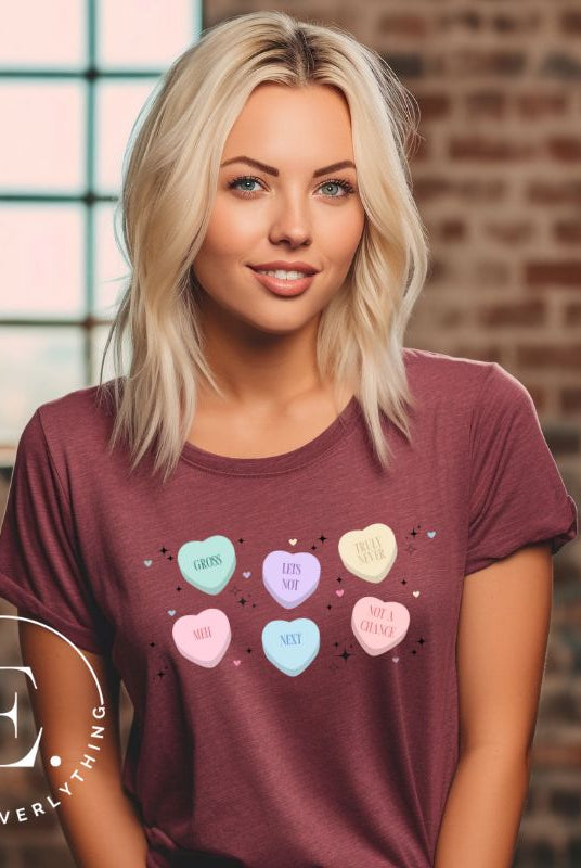 Embrace a humorous take on Valentine's Day with our shirt featuring candy hearts with unconventional messages like "Gross," "Not a Chance," "Next," "Truly Never," "Meh," "Not a Chance," and "Let's Not" on a maroon shirt. 