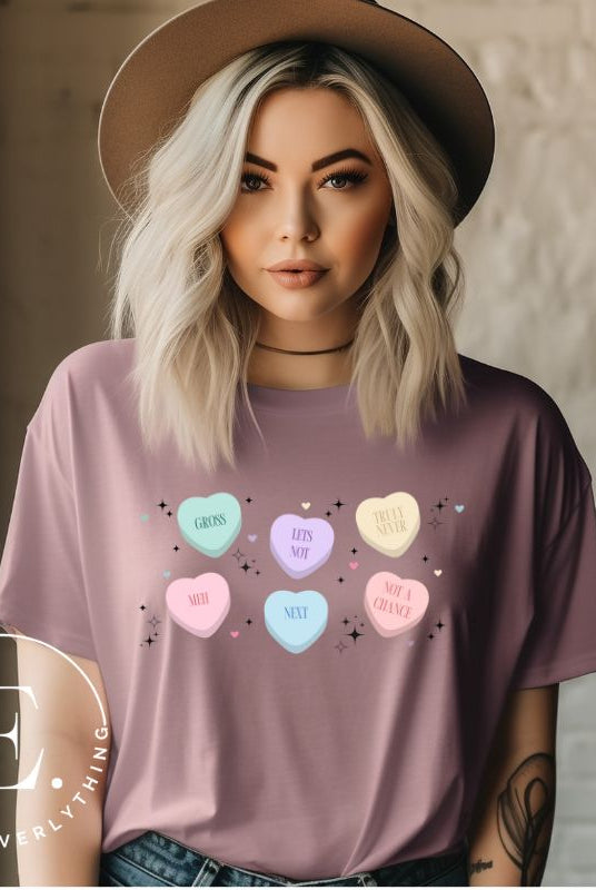 Embrace a humorous take on Valentine's Day with our shirt featuring candy hearts with unconventional messages like "Gross," "Not a Chance," "Next," "Truly Never," "Meh," "Not a Chance," and "Let's Not" on a mauve shirt. 