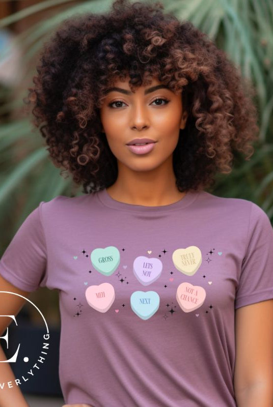 Embrace a humorous take on Valentine's Day with our shirt featuring candy hearts with unconventional messages like "Gross," "Not a Chance," "Next," "Truly Never," "Meh," "Not a Chance," and "Let's Not" on a purple shirt. 