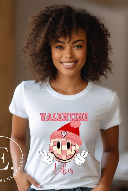 Get into the Valentine's Day spirit with our fun and funky shirt donning the words "Valentine Vibes" alongside a disco ball smiley face flashing peace fingers on a white shirt. 