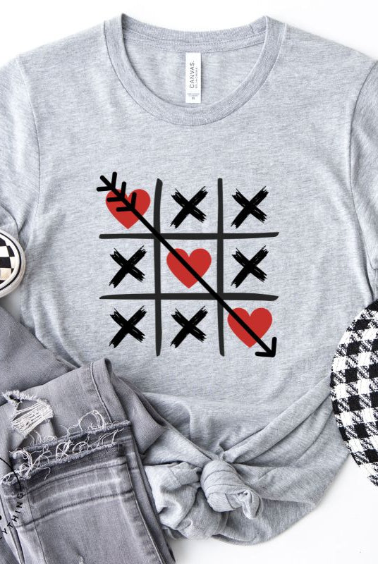 Add a playful twist to Valentine's Day with our Tic-Tac-Toe shirt featuring exes and three hearts. The winning move, an arrow through the three hearts, adds a cheeky touch to this fun and stylish grey shirt. 