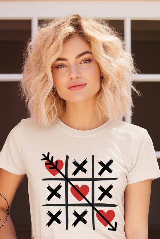 Add a playful twist to Valentine's Day with our Tic-Tac-Toe shirt featuring exes and three hearts. The winning move, an arrow through the three hearts, adds a cheeky touch to this fun and stylish soft cream shirt. 