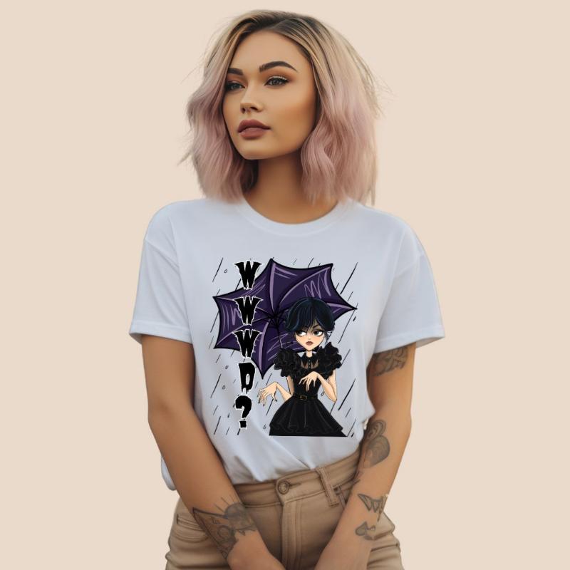 White t-shirt featuring a stylish goth girl dressed in black with a purple umbrella, along with the text "WWWD?" (What Would Wednesday Do?) in bold lettering.