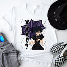 White t-shirt featuring a stylish goth girl dressed in black with a purple umbrella, along with the text "WWWD?" (What Would Wednesday Do?) in bold lettering.