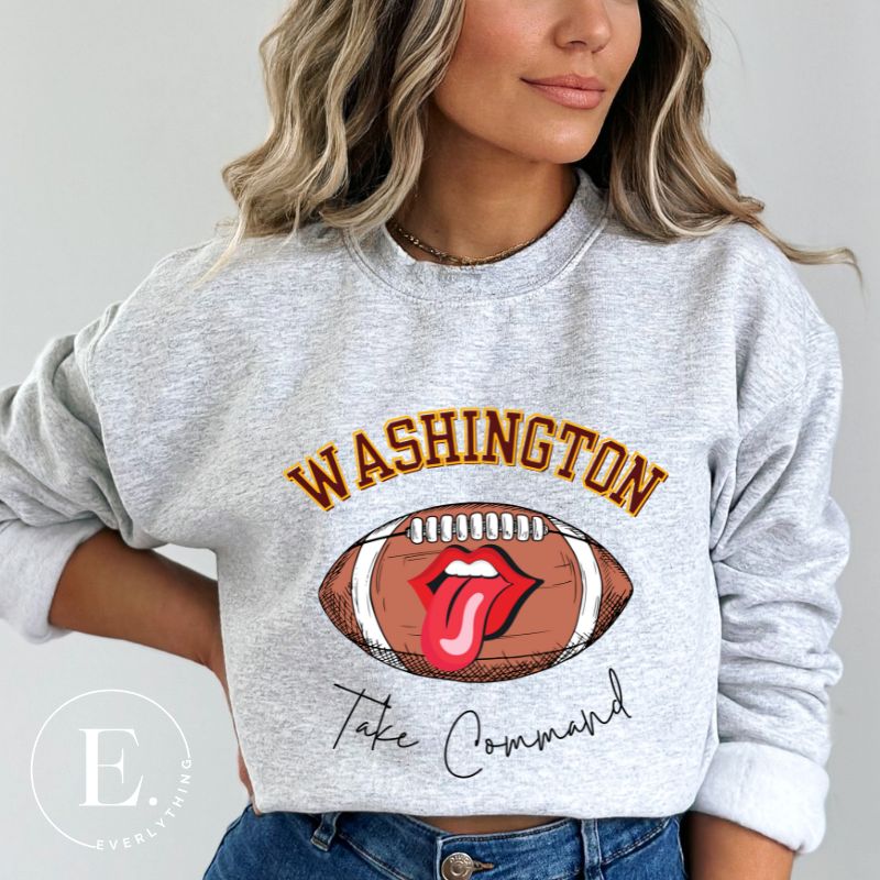 Show your support for the Washington Commanders with this stylish sweatshirt, featuring a football and fun lips and tongue design. Complete with the team's slogan "Take Command" and the distinctive Washington wordmark, on a grey sweatshirt. 