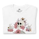 White t-shirt featuring a detailed skeleton design with ribcage and hands intertwined with soft, colorful flowers, blending gothic and floral aesthetics.