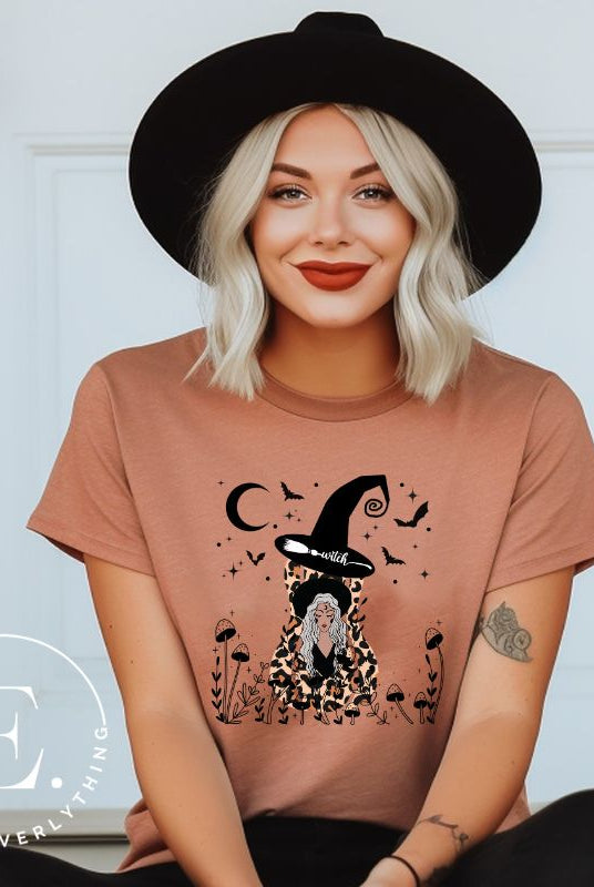 Elevate your Halloween style with our striking shirt featuring a cheetah print squash and a stylish lady donning a witch hat adorned with flowers and bats. Embrace the enchanting fusion of nature and magic on a mauve shirt. 