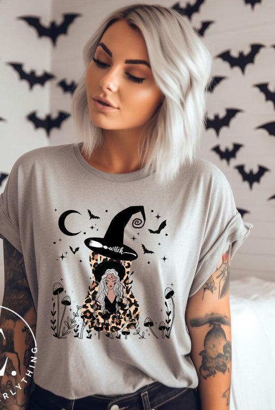 Elevate your Halloween style with our striking shirt featuring a cheetah print squash and a stylish lady donning a witch hat adorned with flowers and bats. Embrace the enchanting fusion of nature and magic on a grey shirt. 