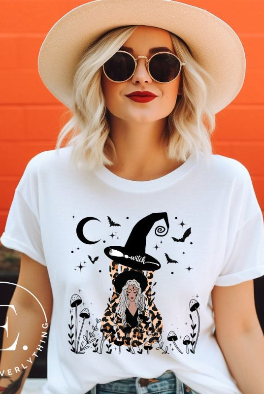 Elevate your Halloween style with our striking shirt featuring a cheetah print squash and a stylish lady donning a witch hat adorned with flowers and bats. Embrace the enchanting fusion of nature and magic on a white shirt. 