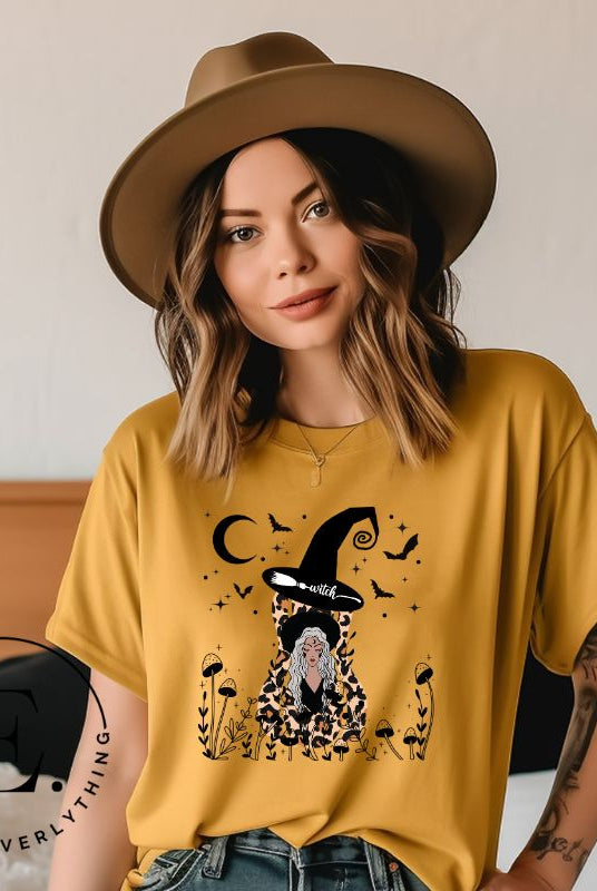 Elevate your Halloween style with our striking shirt featuring a cheetah print squash and a stylish lady donning a witch hat adorned with flowers and bats. Embrace the enchanting fusion of nature and magic on a yellow shirt. 